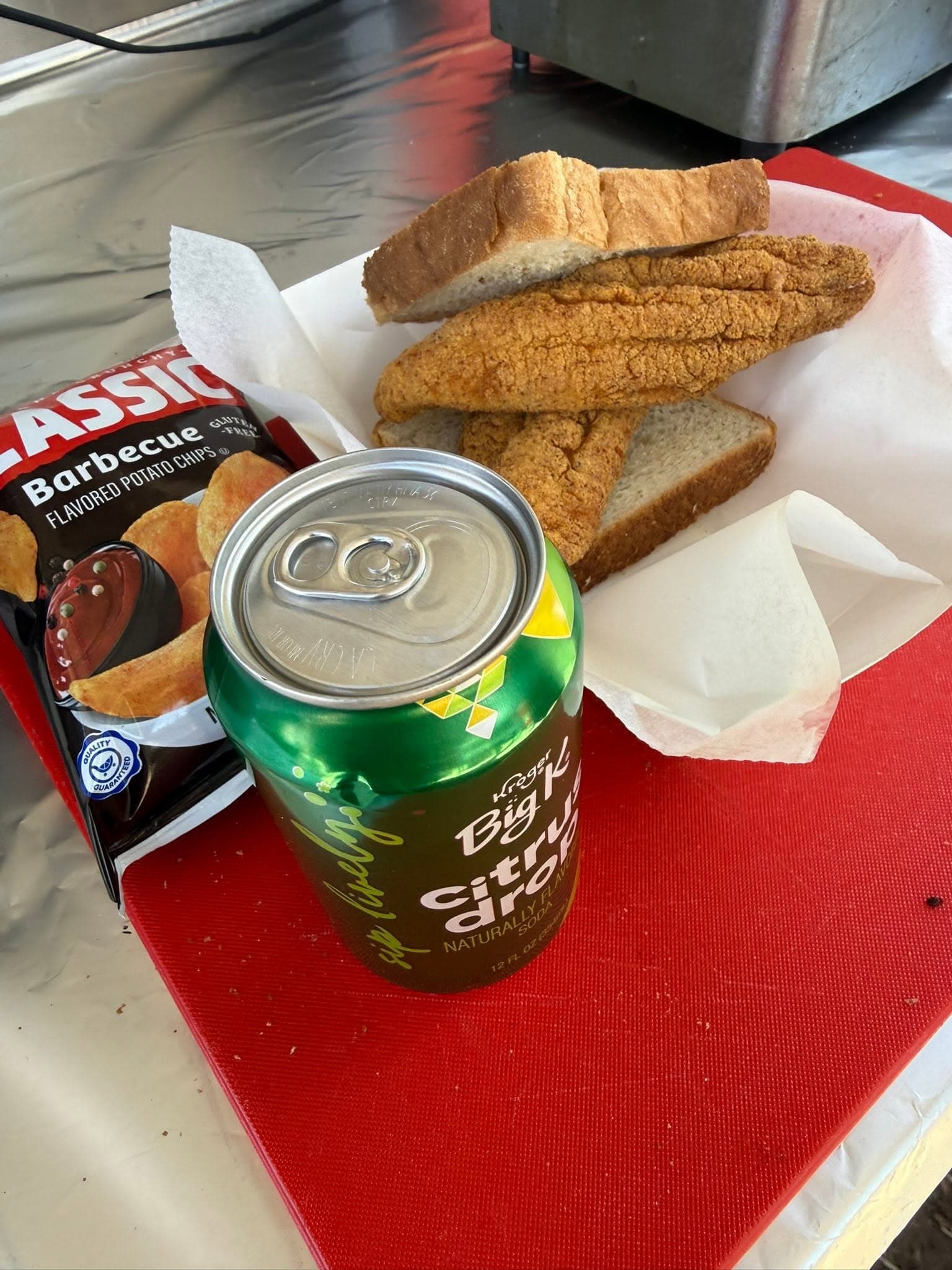 Fried catfish fillets with cornbread on white paper