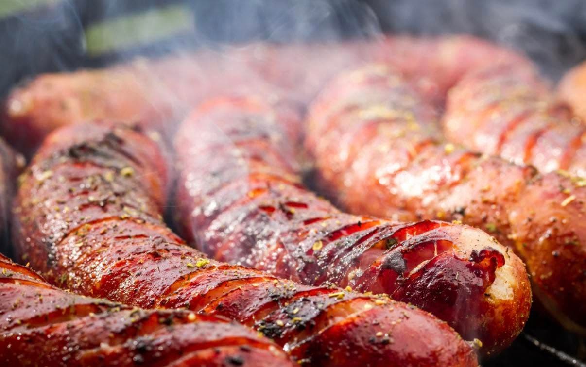 Smoked andouille sausage links with spice coating on the grill