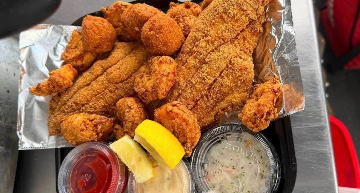 Basket of fried chicken and hushpuppies with lemon wedges